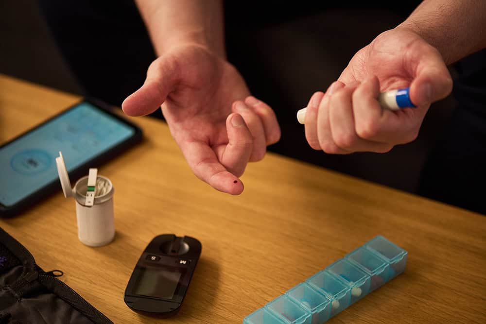 Obesity and Type 2 Diabetes — checking blood sugar with a finger-prick test and glucose meter.
